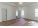 Bright bedroom with hardwood floors, two windows letting in natural light, and view of tub through open door at 212 Mary Caroline Springs Dr, Mount Holly, NC 28120