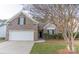 Traditional brick home featuring an attached two-car garage, shuttered windows, and established landscaping at 212 Mary Caroline Springs Dr, Mount Holly, NC 28120