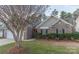 Charming brick home with a well-manicured lawn and dark shutters, complemented by mature trees and a two car garage at 212 Mary Caroline Springs Dr, Mount Holly, NC 28120