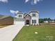Charming two-story home with a stone facade, a two-car garage, and a lush green lawn at 2204 Camber Dr # Cwo0076, Gastonia, NC 28054