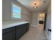 Bright laundry room with large cabinets, quartz countertop, and open shelving at 2204 Camber Dr # Cwo0076, Gastonia, NC 28054