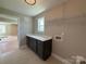 Well-lit laundry room with cabinets, quartz countertops, and open shelving at 2204 Camber Dr # Cwo0076, Gastonia, NC 28054