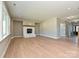 Open living room with a brick fireplace, hardwood floors, and great natural light from surrounding windows at 2204 Camber Dr # Cwo0076, Gastonia, NC 28054