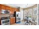 Bright eat-in kitchen showcasing stainless appliances, wooden cabinetry and tile floors at 3008 Sweetleaf Dr, Fort Mill, SC 29707