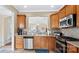Kitchen featuring stainless appliances, wood cabinets, tile flooring, and a pass-through window at 3008 Sweetleaf Dr, Fort Mill, SC 29707