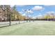 Outdoor tennis court with lights and shaded seating at Sun City Carolina Lakes at 3008 Sweetleaf Dr, Fort Mill, SC 29707