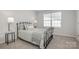 Comfortable bedroom featuring a metal frame bed, soft lighting, and neutral decor at 330 Malvern Sw Ave # A, Concord, NC 28025