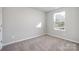 A bright bedroom featuring a large window, wall to wall carpet, and neutral paint at 330 Malvern Sw Ave # A, Concord, NC 28025