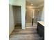 Bathroom with a glass-enclosed shower, wood-look flooring, and shelving near an open closet at 334 Knotty Wood Dr # 68, Monroe, NC 28110