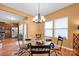 This dining room features a glass table, designer lighting, and bright windows at 4708 Tradd Cir, Monroe, NC 28110
