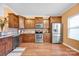 A well-lit kitchen features wood cabinets, stainless steel appliances, and granite counters at 4708 Tradd Cir, Monroe, NC 28110