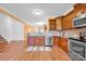 Kitchen with stainless steel appliances, wood cabinets, and view to living spaces at 4708 Tradd Cir, Monroe, NC 28110