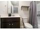 Stylish bathroom featuring dark wood cabinetry, a framed mirror, and combined tub and shower with grey shower curtain at 50143 Robins Nest Ln, Lancaster, SC 29720