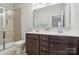 Bathroom featuring dark wood double vanity, a framed mirror, and a glass enclosed shower at 50143 Robins Nest Ln, Lancaster, SC 29720