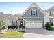 Charming single Gathering home with a white garage door, stone accents, and a well-manicured lawn at 50143 Robins Nest Ln, Lancaster, SC 29720