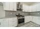 Close-up shot of stainless steel oven and stove with gray brick backsplash and white kitchen cabinets at 5125 Isaac Dr, Charlotte, NC 28216