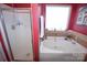 Corner bathtub with a shower and a window featuring decorative plants at 514 Galesburg Dr, Monroe, NC 28110