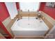 Large bathtub with tile surround, and decorative plants by the window at 514 Galesburg Dr, Monroe, NC 28110