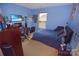 Cozy bedroom with blue walls, furnished with a bed, desk, and gaming setup at 514 Galesburg Dr, Monroe, NC 28110