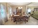 Charming dining area with a wooden table set for eight, complemented by a decorative chandelier and large windows at 514 Galesburg Dr, Monroe, NC 28110