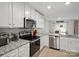 Contemporary kitchen featuring stainless steel appliances, granite countertops, white cabinetry, and a seamless flow into the dining area at 709 Daniel Ln, Richburg, SC 29729