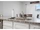 Close-up of kitchen sink highlighting granite countertops, stainless steel faucet, white cabinetry, and a view into the dining area at 709 Daniel Ln, Richburg, SC 29729