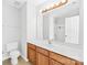 Well-lit bathroom featuring a single vanity, toilet, large mirror, and tub/shower combination at 8263 Carob Tree Ln, Charlotte, NC 28215