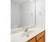 Bathroom with light countertop, wooden cabinet, large mirror, and chrome fixtures at 8263 Carob Tree Ln, Charlotte, NC 28215