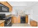 Kitchen featuring black appliances, wooden cabinets, and a view into the bright, open living area at 8263 Carob Tree Ln, Charlotte, NC 28215