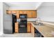 Functional kitchen with black appliances, wood cabinetry, and durable countertops at 8263 Carob Tree Ln, Charlotte, NC 28215