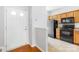 Well-lit kitchen featuring black appliances and wood cabinets, open to the front door entryway at 8263 Carob Tree Ln, Charlotte, NC 28215