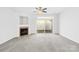 Bright living room with a fireplace, ceiling fan, and sliding glass door to the outside patio at 8263 Carob Tree Ln, Charlotte, NC 28215