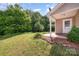 Wide backyard with a small patio and tall trees in the back at 8309 Knapp Ct, Locust, NC 28097