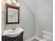 Well-lit half bathroom featuring vanity with framed mirror, and toilet at 8309 Knapp Ct, Locust, NC 28097