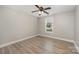Sunlit bedroom showcasing hardwood floors, neutral walls and a modern ceiling fan at 8309 Knapp Ct, Locust, NC 28097
