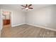 Bright bedroom with modern ceiling fan, light hardwood floors, and ensuite bathroom at 8309 Knapp Ct, Locust, NC 28097