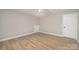 Bright bedroom featuring ceiling fan, light hardwood floors, and trim; natural light from window at 8309 Knapp Ct, Locust, NC 28097