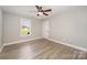 Bright bedroom features light hardwood floors, white trim, and a window offering natural light at 8309 Knapp Ct, Locust, NC 28097
