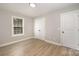 Bright bedroom with window, closet doors, light hardwood floors, and trim at 8309 Knapp Ct, Locust, NC 28097