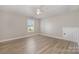 Bright bedroom featuring ceiling fan, window with blinds, light hardwood floors, and white trim at 8309 Knapp Ct, Locust, NC 28097