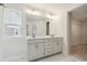 Bright bathroom with double vanity, large mirror, and marble-look tile at 10113 Mamillion Dr, Huntersville, NC 28078