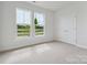 Well-lit bedroom features plush carpet, double door closet, and view of front yard at 10113 Mamillion Dr, Huntersville, NC 28078