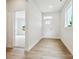 Bright foyer with wood-look flooring, white walls, and natural light streaming through the front door and window at 10113 Mamillion Dr, Huntersville, NC 28078