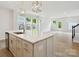 Open concept kitchen with a large island, stainless steel sink, and view to backyard at 10113 Mamillion Dr, Huntersville, NC 28078