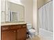 Well-lit bathroom with cherry wood vanity, granite countertop, and shower with white curtain at 11604 Bradford Park Dr, Davidson, NC 28036