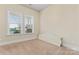 Bright bedroom with neutral carpet, large windows, and calming neutral paint at 11604 Bradford Park Dr, Davidson, NC 28036