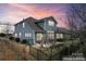 Back of a two-story house featuring a fenced backyard with a patio and a colorful sky at 11604 Bradford Park Dr, Davidson, NC 28036
