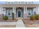 Close-up of a charming front porch with brick accents, white columns, and a welcoming entrance at 11604 Bradford Park Dr, Davidson, NC 28036