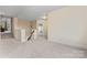 Spacious hallway with neutral carpet and paint, leading to staircase and other rooms at 11604 Bradford Park Dr, Davidson, NC 28036
