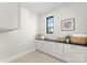 Well-organized laundry room with built-in cabinetry and a view from the window at 19405 Coachmans Trce, Cornelius, NC 28031